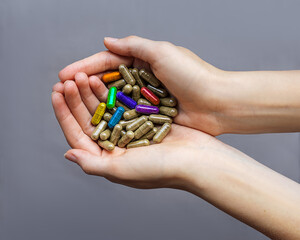 Among the faceless capsules without color in women's hands are rainbow capsules of the color of the LGBT flag. Homosexual relationships. conceptual close-up photo