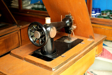An old model of sewing machine on wood table © surasak
