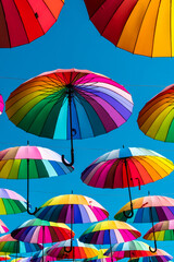 Fototapeta na wymiar Rainbow umbrella above the street, LGBT symbols.