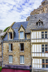 Fototapeta premium Buildings fragment of Abbey Mont Saint-Michel (7th century) at rocky tidal island in Normandy - one of most visited tourist sites in France. Mont-Saint-Michel in UNESCO list of World Heritage Sites.