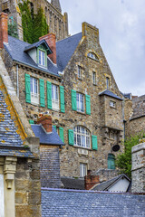 Buildings fragment of Abbey Mont Saint-Michel (7th century) at rocky tidal island in Normandy - one of most visited tourist sites in France. Mont-Saint-Michel in UNESCO list of World Heritage Sites.