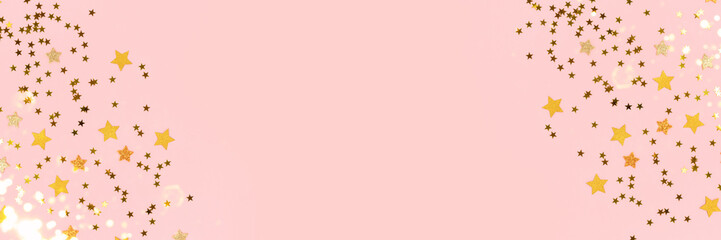 Obraz premium Frame made of gold stars confetti scattered on a pink pastel background. Banner with copy space.