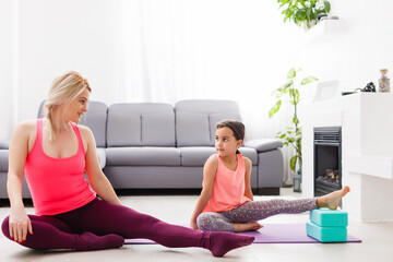 Mother and daughter practicing yoga at home