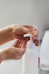 Hand sanitizer alcohol gel rub clean hands hygiene prevention of coronavirus virus outbreak. Woman  using bottle of antibacterial sanitiser soap