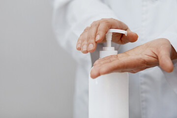 Doctor hand using alcohol wash gel for cleaning sanitize gel pump dispenser. Bottle of  hand...