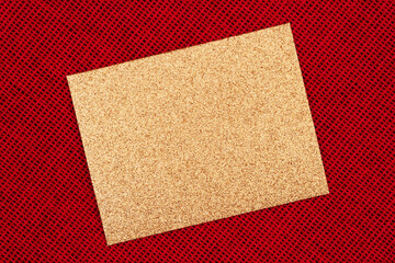 Blank gold glitter greeting card on red wicker textured weave