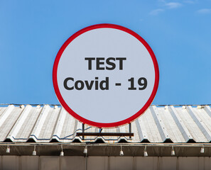A Circle billboard with icon a symbol fast test for check coronavirus, is installed on a roof.