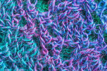 handmade multicolor crochet background in blue, green and purple with chain stitches and triple crochet stitches
