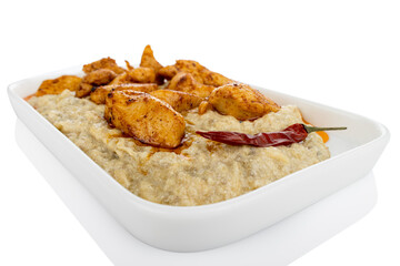 Chicken with aubergine puree, on white plate, on white background (Tr- Tavuk begendi)
