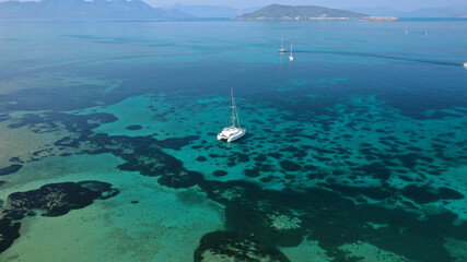 Aerial drone photo of catamaran sailing yacht anchored in tropical exotic emerald sea coral reef bay