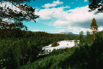 Norway’s national waterfall Målselvfossen. Beautiful view to the flowing and disturbed water,...