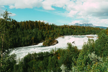 Norway’s national waterfall Målselvfossen. Beautiful view to the flowing and disturbed water,...