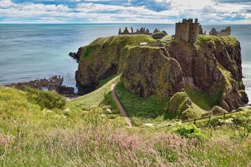 Ruins of Dunnottar Castle on Aberdeenshire coast, Scotland on a sunny summer day with dramatic sky