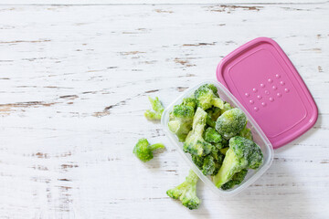 Healthy food is frozen. Containers with frozen broccoli. Top view flat lay background. Copy space.