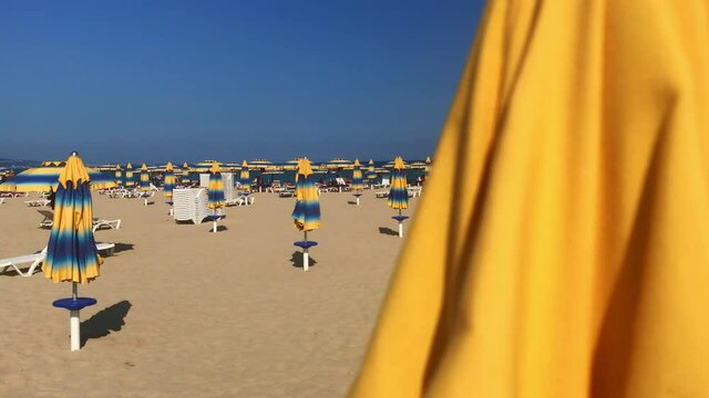 Showing an empty beach with closed beach umbrellas as a consequence of Covid-19