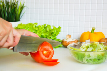 Human hands cooking vegetables salad in kitchen