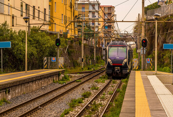 A view down a platform with a train approaching on the railway line between Naples and Sorrento, Italy