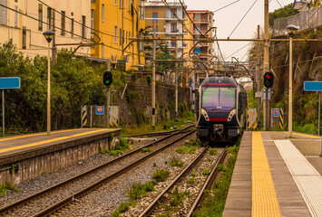 Fototapeta premium A view down a platform with a train approaching on the railway line between Naples and Sorrento, Italy