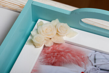 Roses with petals made of white polymer clay. Glued to the photo frame. Crafts from polymer clay.