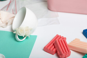 Roses with petals made of white polymer clay. Glued to a mug. Crafts from polymer clay.