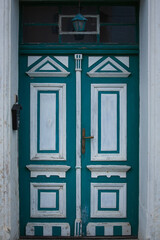 Green entrance door with white elements