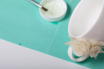 Roses with petals made of white polymer clay. Glued to a mug. Crafts from polymer clay.