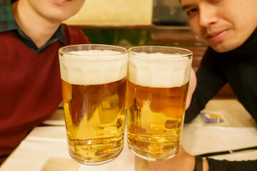 Human hand holding a big glass of beer in restaurants
