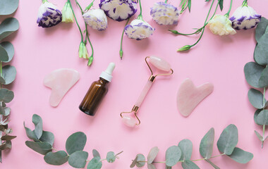 Facial massage kit made from rose quartz and a bottle of essential oil.