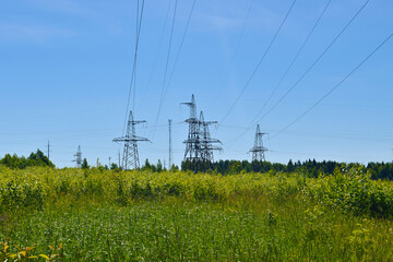 High-voltage power line outside the city in the field during the day