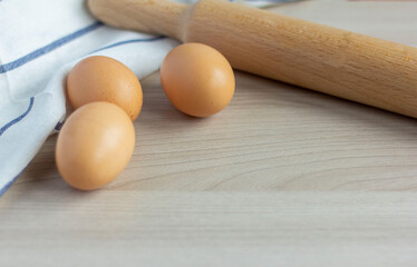 Homemade chicken eggs and a rolling pin on the table.Preparation for cooking.Copy of the space.
