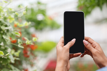 Photo for blog about plants. Hands of african american girl working on smartphone