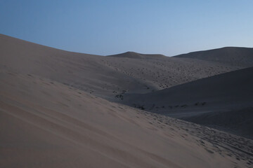 sand dunes and blue sky at dusk. wide angle. At Dunhuang,Gansu province,China