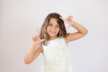 Fototapeta premium Beautiful little girl making portrait gesture