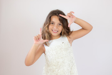 Fototapeta premium Beautiful little girl making portrait gesture