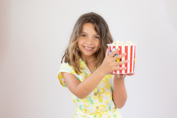 Portrait of a pretty girl with yellow shirt with popcorn in hand