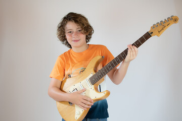 Fototapeta premium Boy in orange shirt playing guitar
