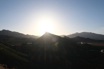 bright sunset sunshine above mountain peak silhouette. At Zhangye, Gansu province China.