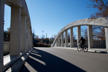Amazing view of a bridge over the river with a man riding the bicycle
