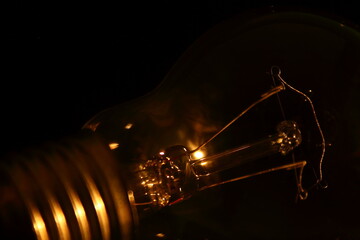 Glowing light bulb in the dark, socket detail