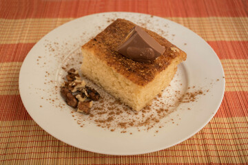 homemade cake with cinnamon, nuts and chocolate in a white plate