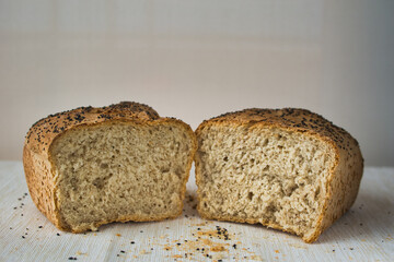 wholemeal bread with chia seeds broken in half isolated on white and copy space top