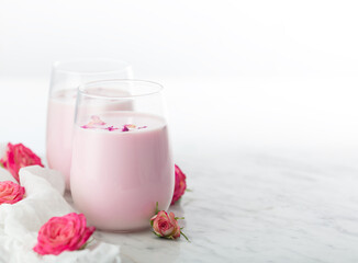 Moon milk prepares with pink rose flower. Trendy relaxing bedtime drink form Ayurvedic traditions