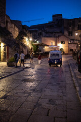Tourists on a Piaggio Ape Calessino used as a tourist taxi in the Sassi di Matera a historic district in the city of Matera; well-known for their ancient cave dwellings. Basilicata. Italy