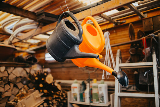 Two watering cans in a garden shed