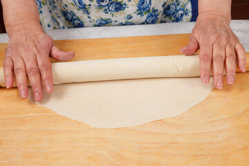 Dough and rolling pin on wooden board