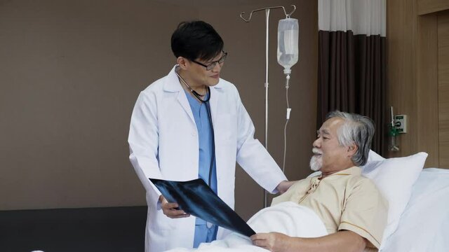 Doctor talking Consultant the elderly man patient in the hospital. Explain an X-ray about cancer treatment, lung disease and physical health. Clean clinic to prevent bacteria and Coronavirus