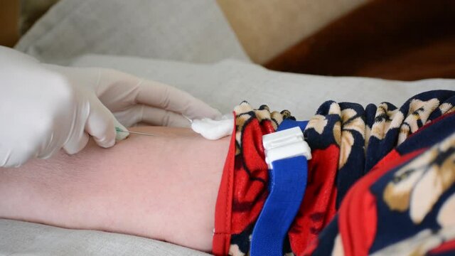 Intravenous injection, medical injection. Nurse makes an intravenous injection of an elderly woman.