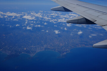 View from the plane, saw the plane wing The sea and the terrain are below