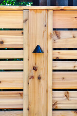 Close up detail of deck light on a contemporary minimalist cedar fence.