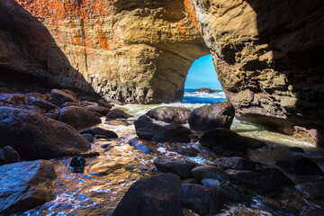 Photo taken inside Devil's Punchbowl, looking out through a rock window at the Pacific ocean.